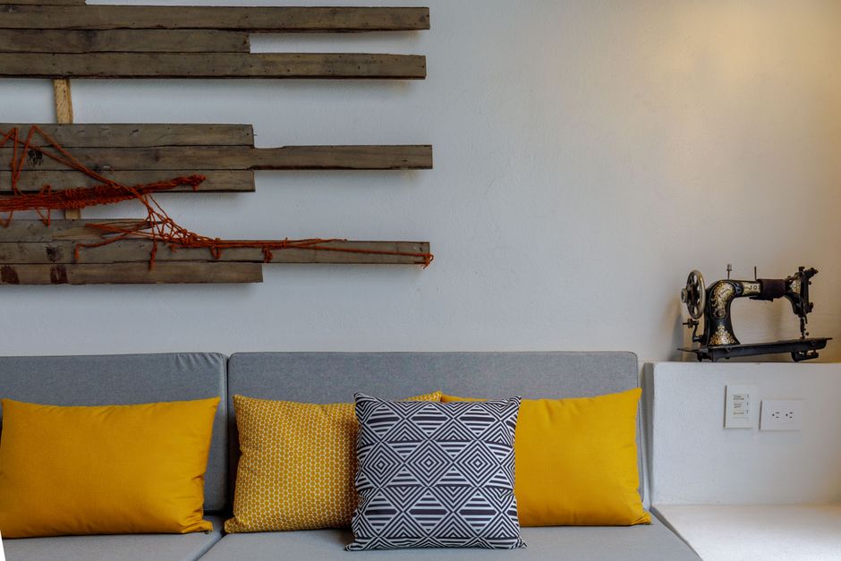 Contemporary interior with vibrant pillows, artistic wall decor, and vintage sewing machine.